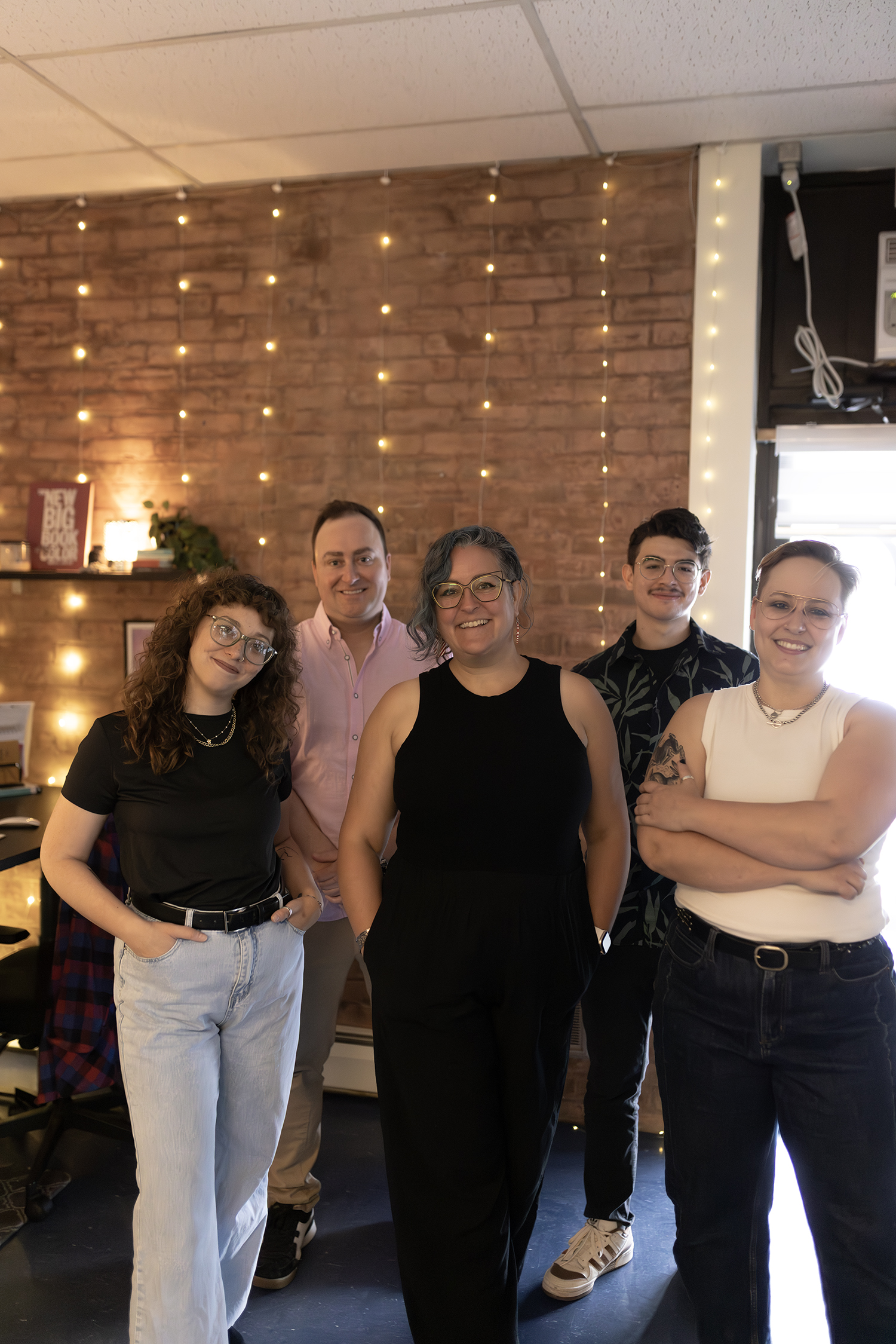 Team-Cave Frolic Design team photo where 5 staff member are standing and smiling in their studio space
